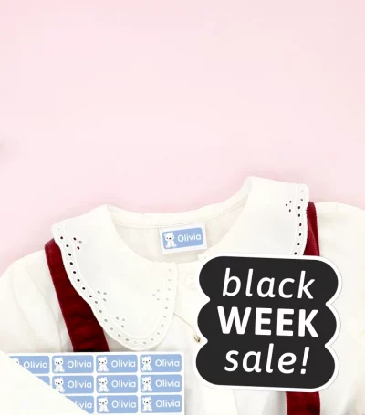 Lasten kengät ja mekko, joissa on nimitarroja, ympärillä lumihiutalekoristeita. Black Week