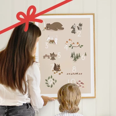 Aikuinen ja lapsi katsomassa seinällä olevaa numerojulistetta, jossa on metsäeläimiä.