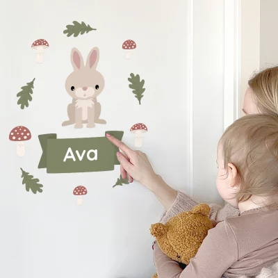 Söpöt lasten ovitarrat, joissa on kani ja nimi ”Ava” vihreällä kyltillä, vihreiden lehtien ja sienten ympäröimänä. Täydellinen lastenhuoneen personointiin ja kodikkaan tunnelman luomiseen.