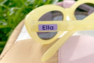 Aurinkolasit, joissa on nimilappu Ella. Valoisa ja värikäs design, täydellinen lapsille. Sopii hyvin kesäisiin ulkoiluihin ja leikkeihin.